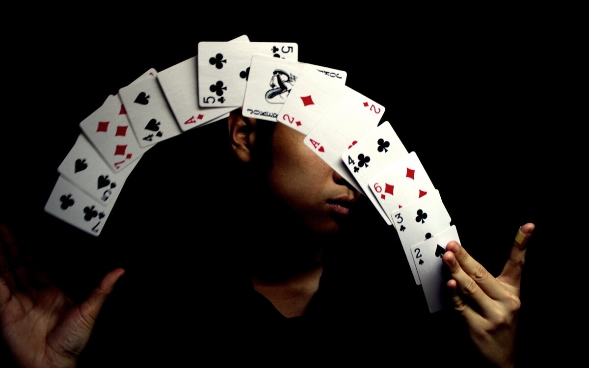 мужчина с картами в руках. человек с картой. шулер с колодой в руках. игральные карты. шулер с колодой в руках.