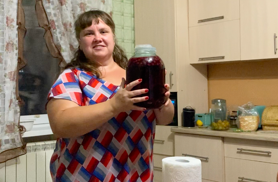 Наталья, держит в руках клубнично-вишневый морс из собственного погреба. 