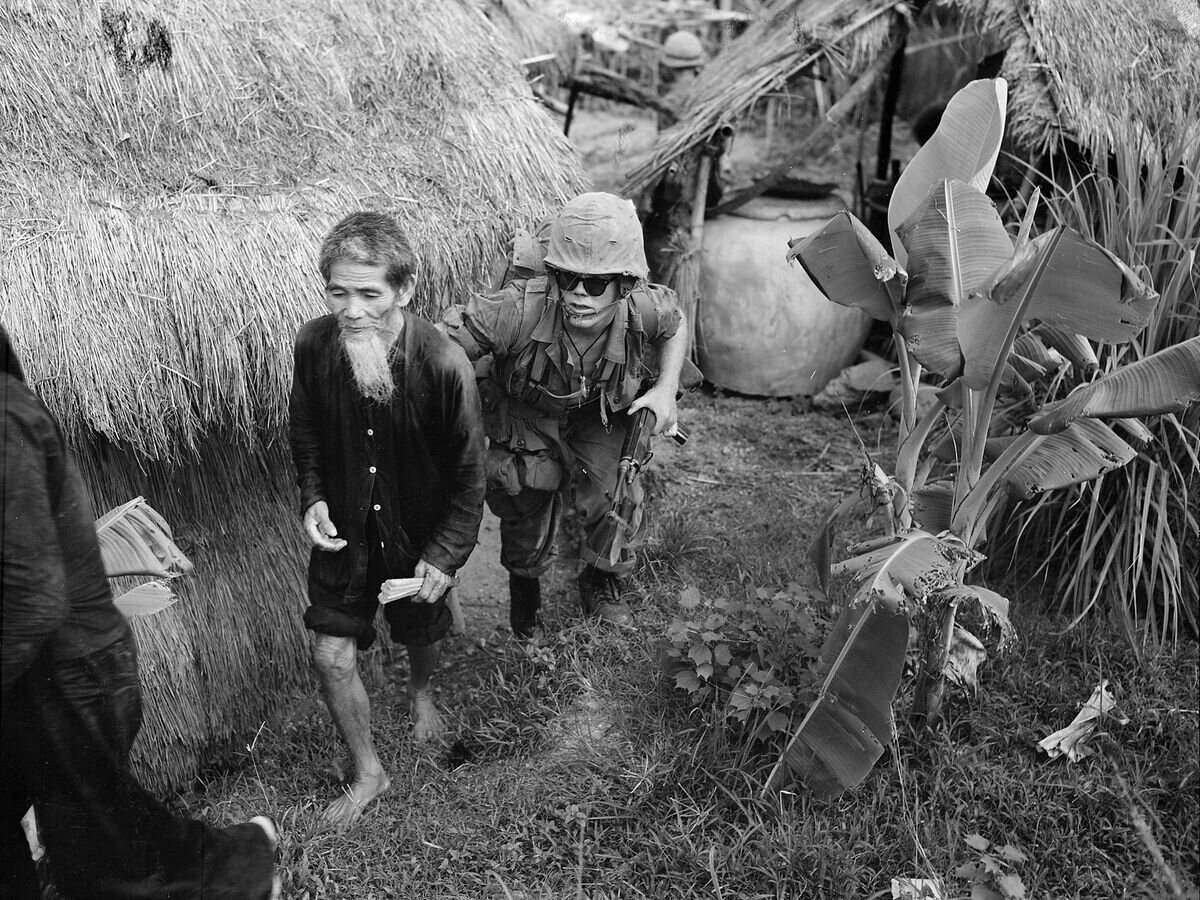    Американский морской пехотинец конвоирует вьетнамца, подозреваемого в принадлежности к НФОЮВ. Район Дананга, август 1965 года© Фото : Public domain