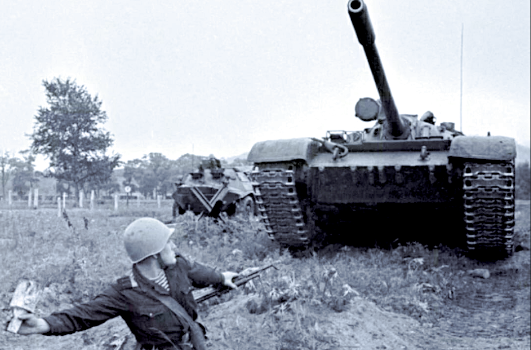 Сапёр бросает мину под гусеницы немецкого танка.