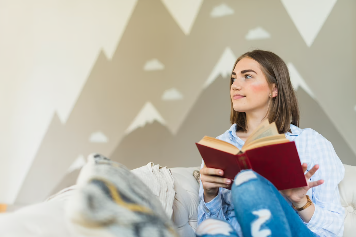 Чтение досуг. Диван книга. Книга на диване картинки. Книжный Холдинг. Girl sitting with book.