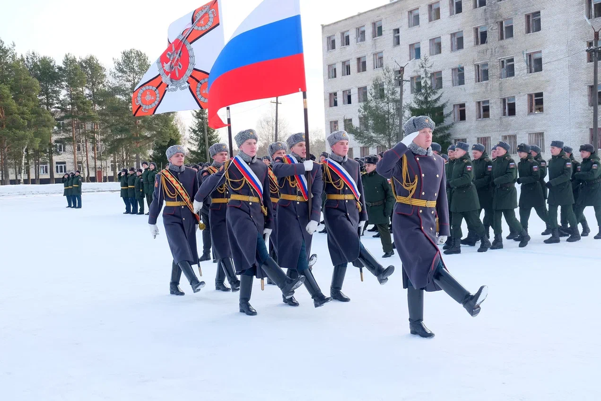 Знамённая группа торжественно печатает шаг перед строем сослуживцев