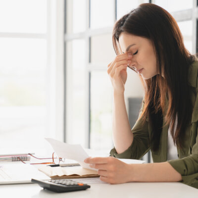    Young tired stressed overworked businesswoman freelancer teacher student exhausted after hard work, suffering from migraine headache at office. Deadline, fired worker, debt, problems concept Валерий