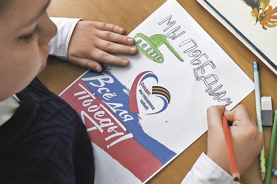     Младшеклассник дивногорской школы № 2 имени Гагарина шлет поздравления участникам СВО, где сейчас девять выпускников этой школы. Фото: Илья НАЙМУШИН/РИА Новости