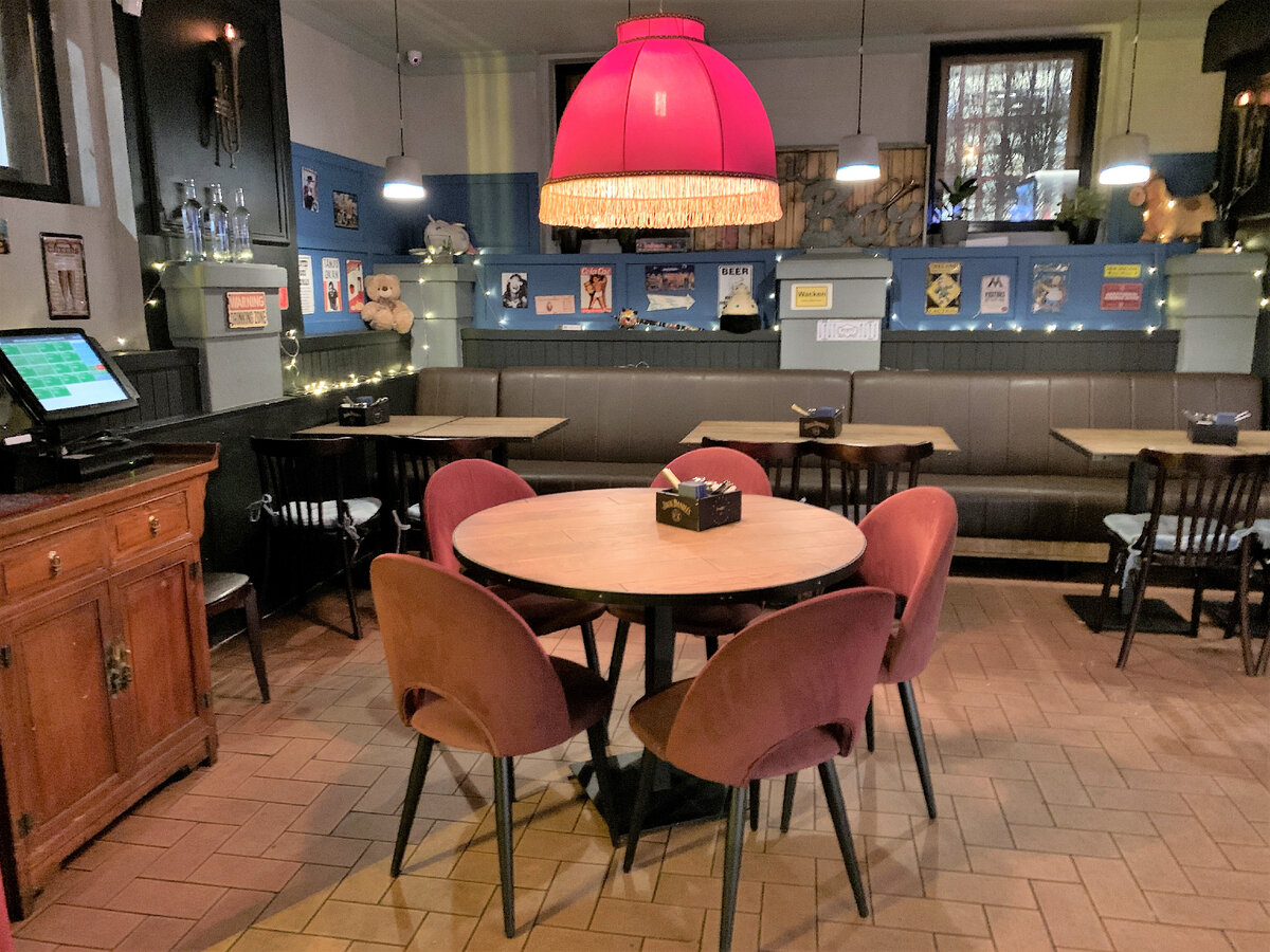 Диван вдоль стены и столики под красными абажурами