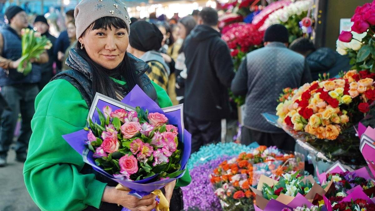    Женщина держит цветы:NUR.KZ/Владимир Третьяков