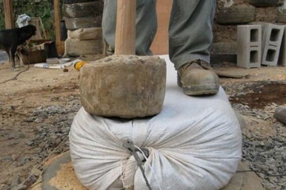 Вот так трамбуется грунт в мешках при создании стен дома по технологии Earthbag building