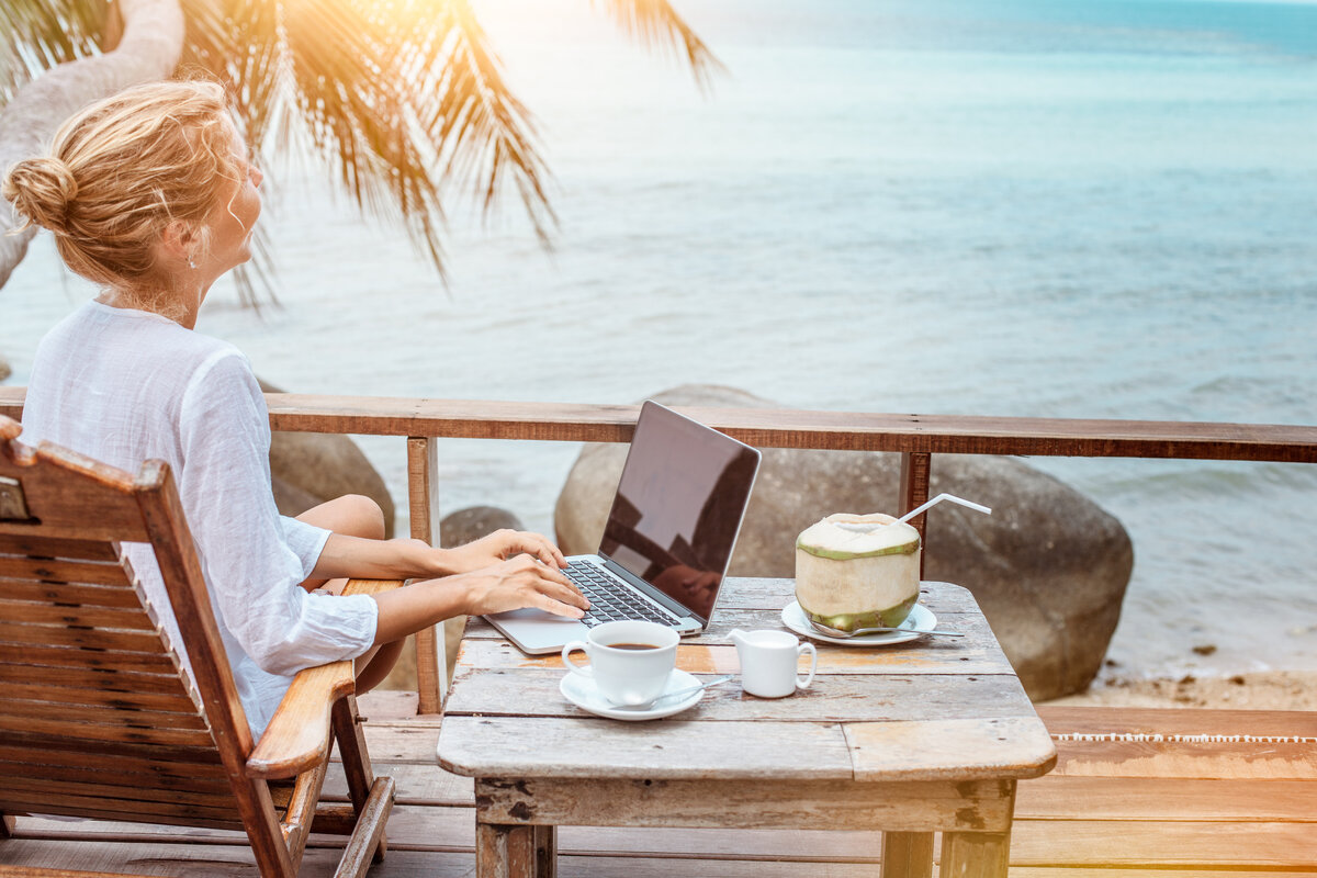 Полдня отпуск. Столик у моря. Девушка с ноутбуком на террасе. Ноутбук на берегу моря. С ноутбуком на море.