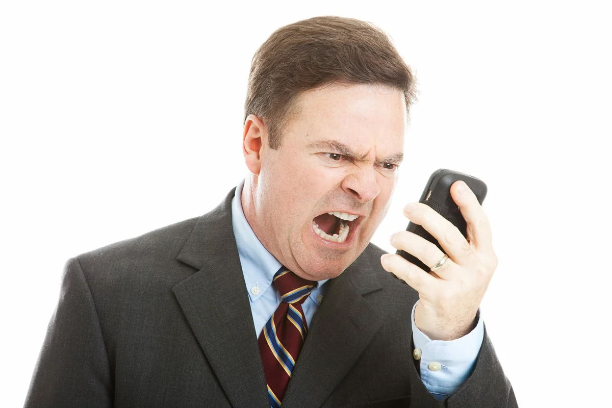 Угрожающий образ. Злой бизнесмен. Кричит в телефон. Человек кричит в телефон. Недовольный человек.