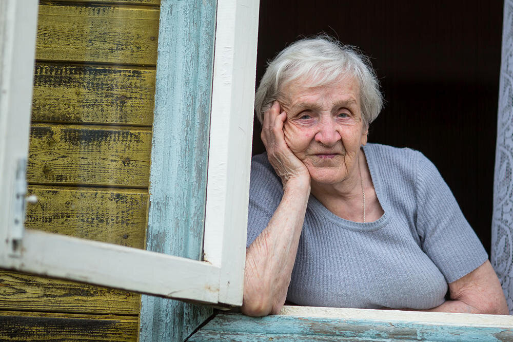 Фото людей 80 лет. Бабушка у окна. Бабушка выглядывает из окна. Пожилая женщина у окна. Бабки в окне.