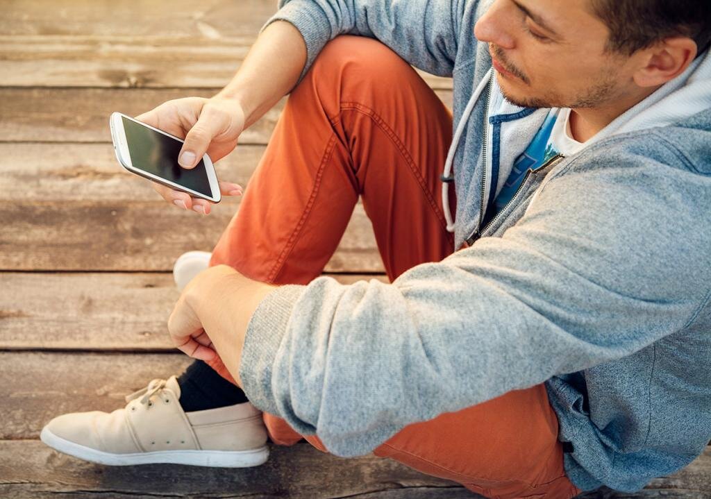 парень сидит в телефоне