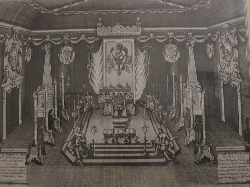 Вид Печальной залы. Оформление "Печальной залы" было преимущественно имперским и военным по своей тематике. Над ним работали лучшие архитекторы и художники. Однако, кроме обычных украшений, использовавшихся в подобных случаях на Западе (фигуры, гербы, символы), в зале были поставлены также пирамиды с надписями. Стены залы первоначально были обиты шпалерами с изображением "Чудес Христовых", но Екатерина I, взглянув на них, велела Брюсу и Боку обить их просто чёрным сукном.
В центре залы было сделано возвышение, покрытое кармазинным бархатом и золотыми коврами ("амвон"). На нём был поставлен покрытый золотой парчой одр под богатым балдахином. На современной гравюре видно, что Пётр лежит в своём гвардейском мундире. В изголовье на подушках лежат короны. Вдоль стен – почётный караул.