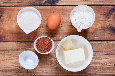 Как испечь классическое домашнее шоколадное печенье? Подготовьте продукты для приготовления печенья. Масло и яйцо достаньте заранее, чтобы они стали комнатной температуры. Сахар лучше брать мелкий или сахарную пудру. Соли совсем немножко, несколько кристаллов. Яйцо размером С1.