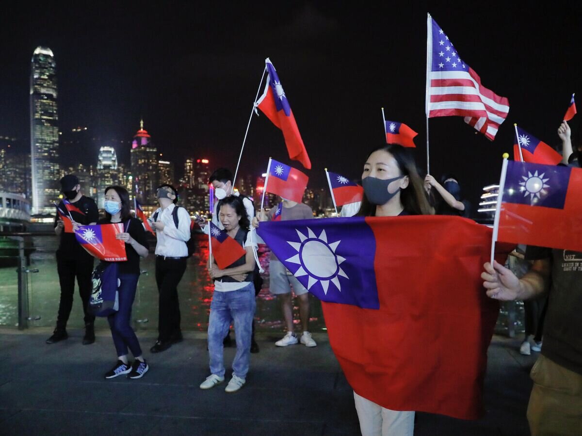    Люди c флагами Тайваня и США на митинге по случаю Национального дня Тайваня в Гонконге© AP Photo / Kin Cheung