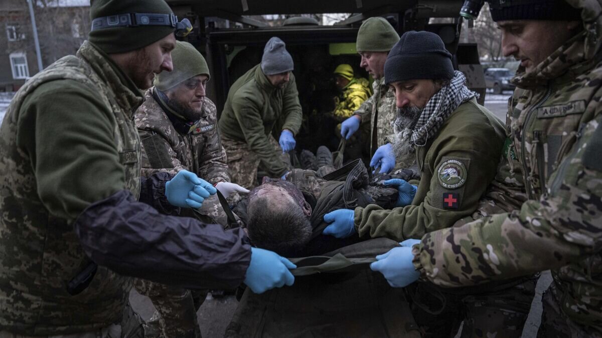    Украинские военнослужащие транспортируют раненого в госпитале в Донецкой области© AP Photo / Evgeniy Maloletka