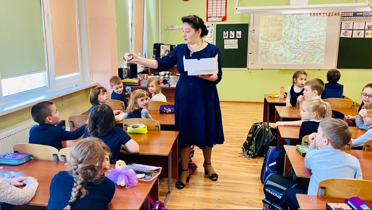 В школе Катя и Кариша внимательно слушают учительницу. 