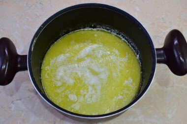 ШАГ 2:
Для приготовления теста на эклеры соедините воду и сливочное масло. Поставьте на огонь, доведите до кипения и проварите пару минут, чтобы масло полностью растаяло и смешалось с водой.