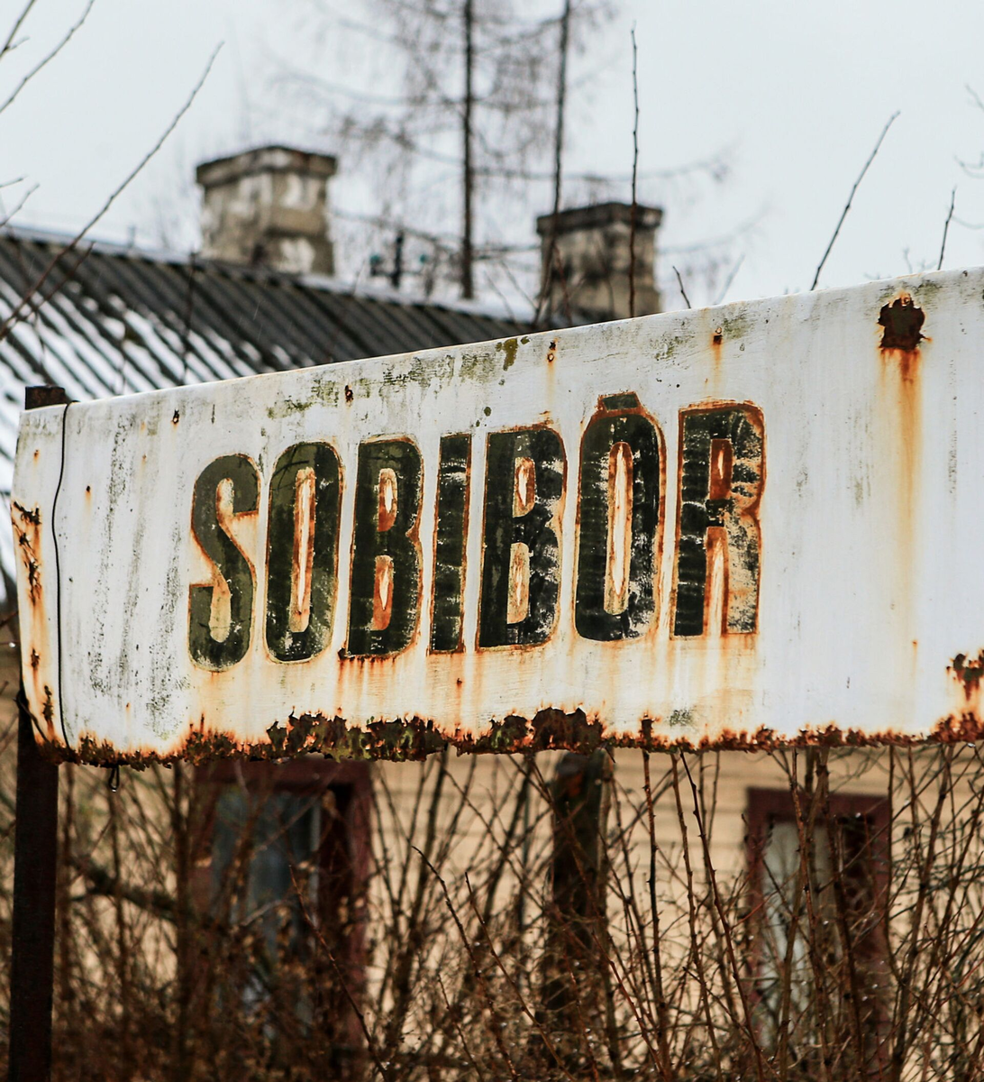 Некогда эта табличка означала въезд на территорию концентрационного лагеря Собибор, а ныне - извещает о наличии музея памяти жертв Холокоста. Фотография в свободном доступе.