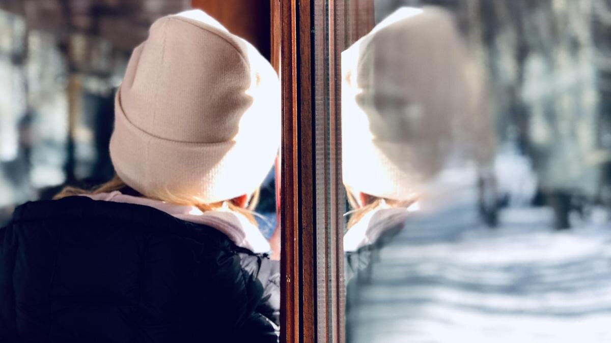    Девушка смотрит в окно из автобуса на снежную улицу:pexels.com