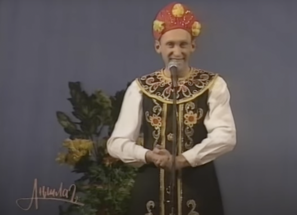 В нелепом красно-желтом кокошнике работал смешил довольную публику