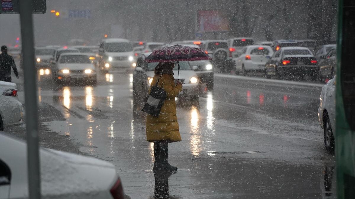    Женщина с зонтом на дороге:NUR.KZ / Владимир Третьяков