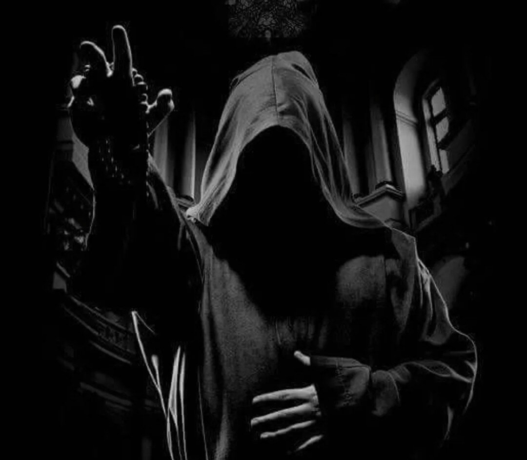 Монах в капюшоне в темноте