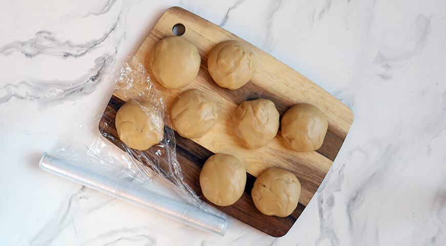 1. Приготовьте тесто для коржей торта. Растопите на слабом огне масло, добавьте мед, прогрейте и снимите с огня. Добавьте соду и перемешайте. Взбейте яйца с сахаром в пышную пену, добавьте муку и масляную смесь и замесите тесто. Разделите тесто на 6-8 частей, скатайте каждую в шар, заверните в пленку и уберите на 30 мин в холодильник.