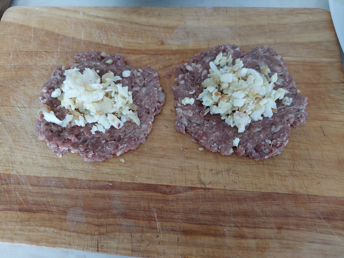 Фарш разравниваю на доске, на середину кладу яично-луковую начинку, соединяю края и готовые зразы укладываю в форму.