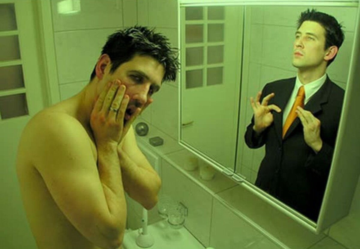 Человек отражается в зеркале