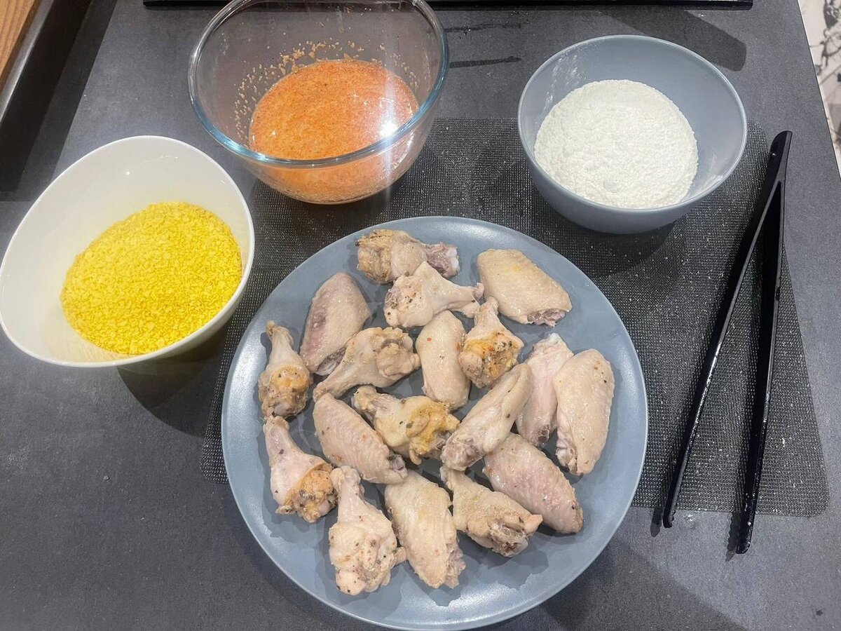 Разрезать крылья на фаланги по суставам. Залить водой и довести до кипения на небольшом огне. Варить не более 5 минут, достать и дать им немного остыть.
Любым удобным способом измельчить хлопья. (Отличный вариант замены - сухой батон, но не готовая панировка)