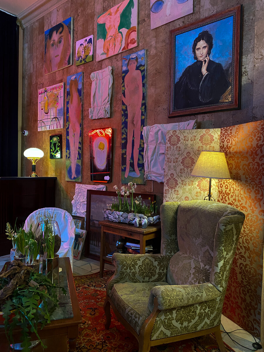 Поп-ап-галерея на рецепции. На переднем плане портрет Джейн МакГилл. Ширмы обтянуты старыми шторами. Кресло — из гостиничных запасов,