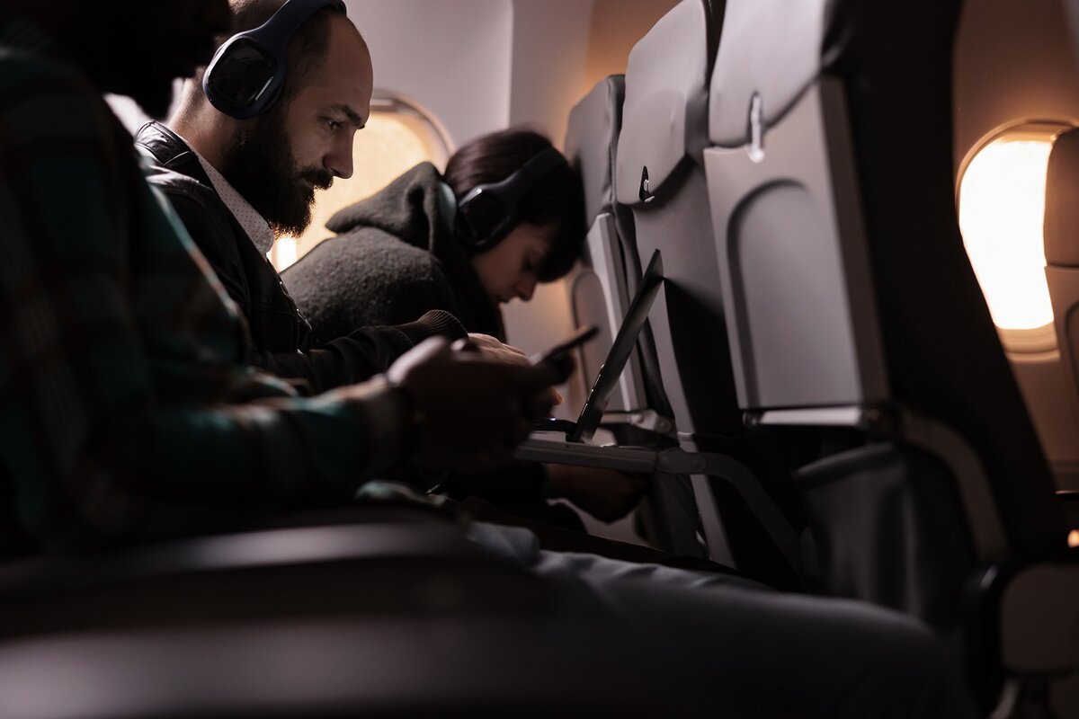    Diverse group of people travelling on commercial flight with international airways service. Flying with plane during sunset to arrive at airline destination, feeling scared about takeoff and flight.