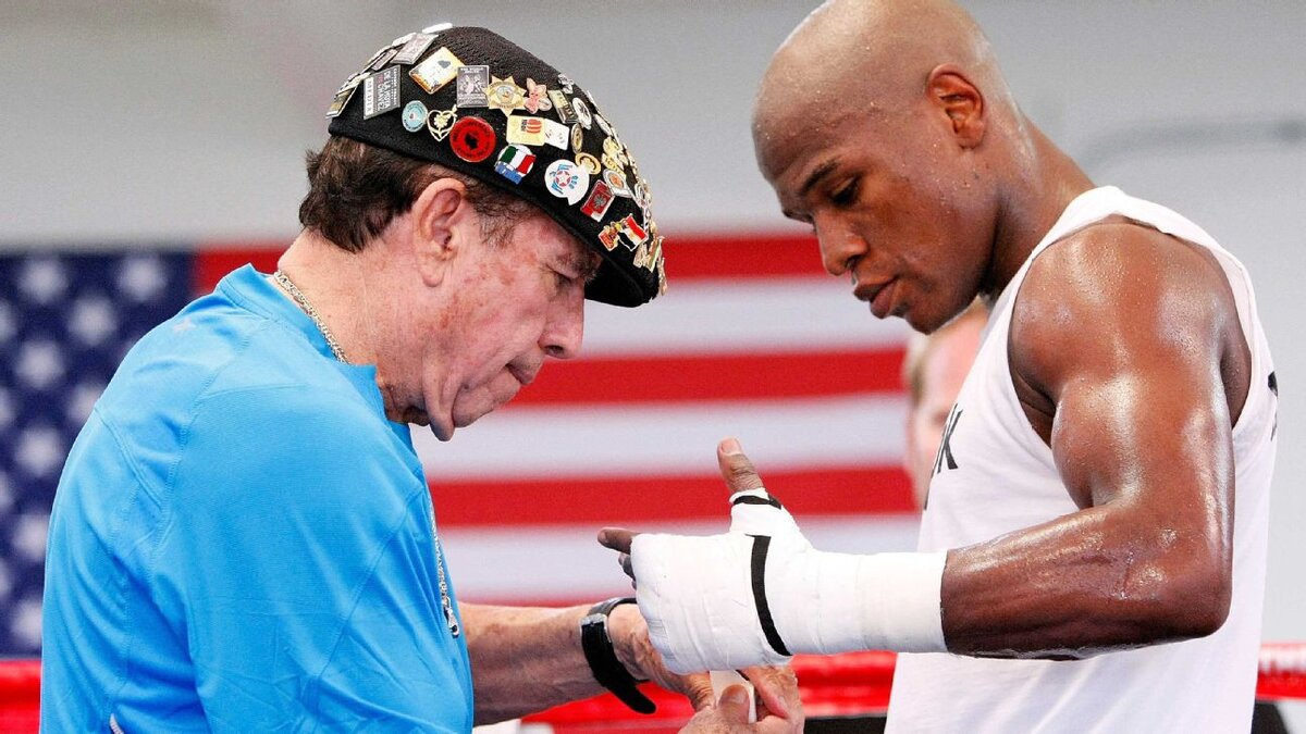 Рафаэль Гарсия тейпирует руки Флойда Мейвезера в ходе подготовки к очередному бою