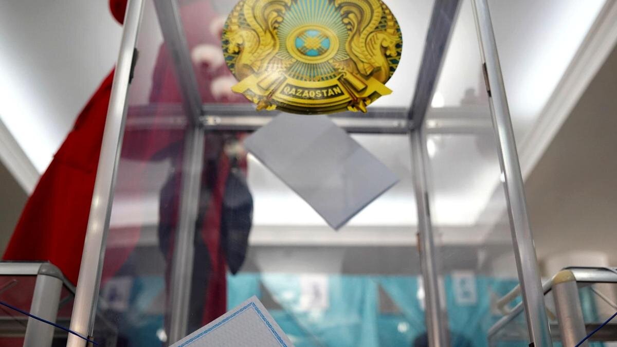    Женщина бросает бюллетень в урну:NUR.KZ / Владимир Третьяков