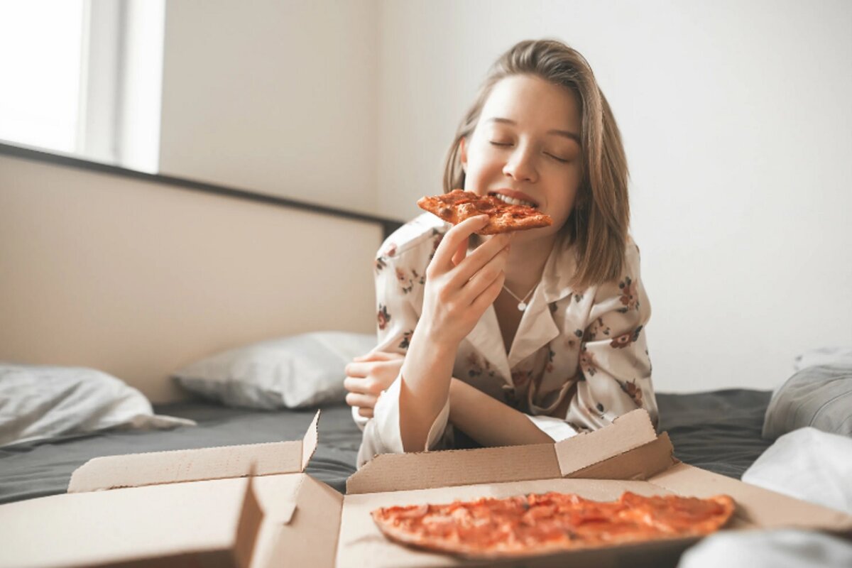 Девушка с пиццей на диване