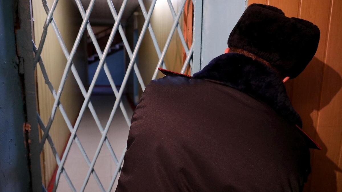    Полицейский закрывает дверь:NUR.KZ/Петр Карандашов