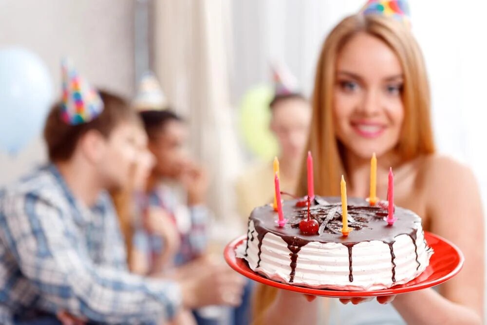 Девушка блондинка держит торт красивый. Человек в колпаке держит торт. Толпа держит торт. Отметить день рождения заранее на 1 день
