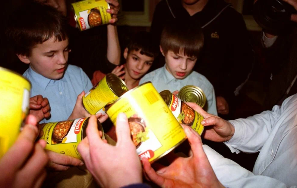 Воспитанники детского дома №28 рассматривают банки с мясоовощной смесью, подаренные германской туристической фирмой «Олимпиа-Райзен". 