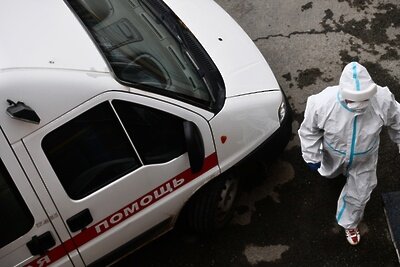    Врач в защитном костюме у автомобиля скорой медицинской помощи ©Павел Лисицын РИА Новости