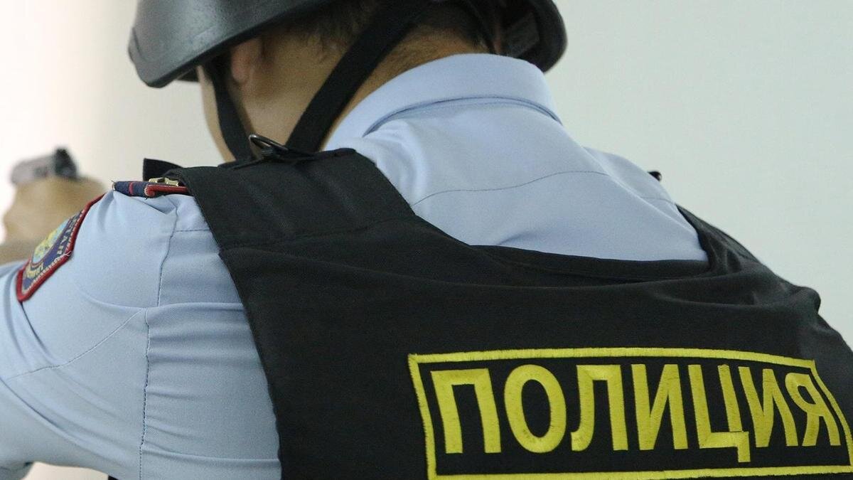    Полицейский держит в руках оружие:NUR.KZ/Петр Карандашов