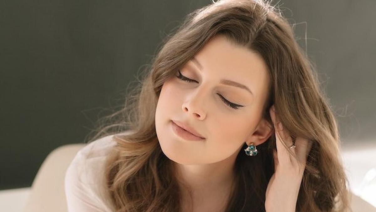    Красивая девушка с длинными каштановыми волосами и закрытими глазами:Pexels