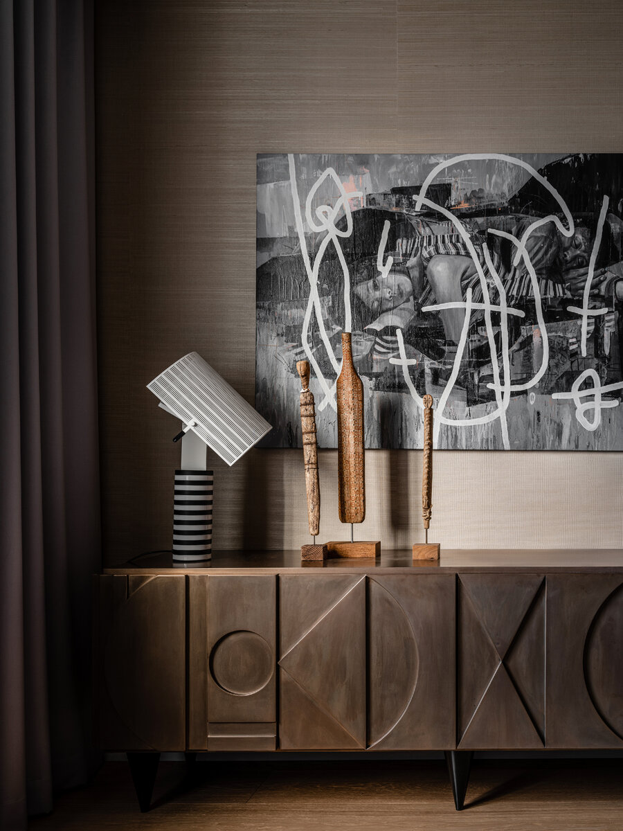 На комоде по дизайну Анны лампа Марио Ботты для Artemide и арт-объекты Дмитрия Рытяева. На стене работа Марата Морика из Ruarts Gallery. 

