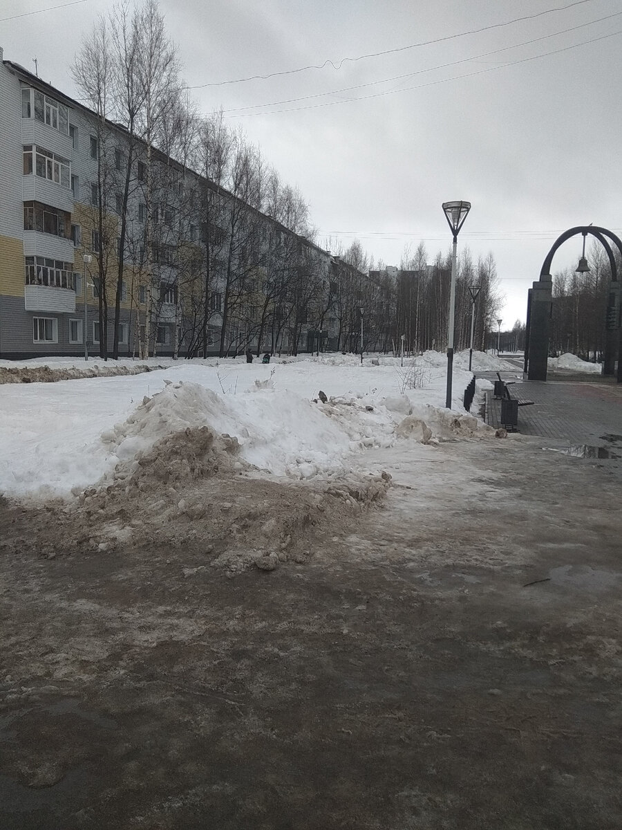 А рядом с прочищенным до плитки тротуаром - горы серого, оседающего снега