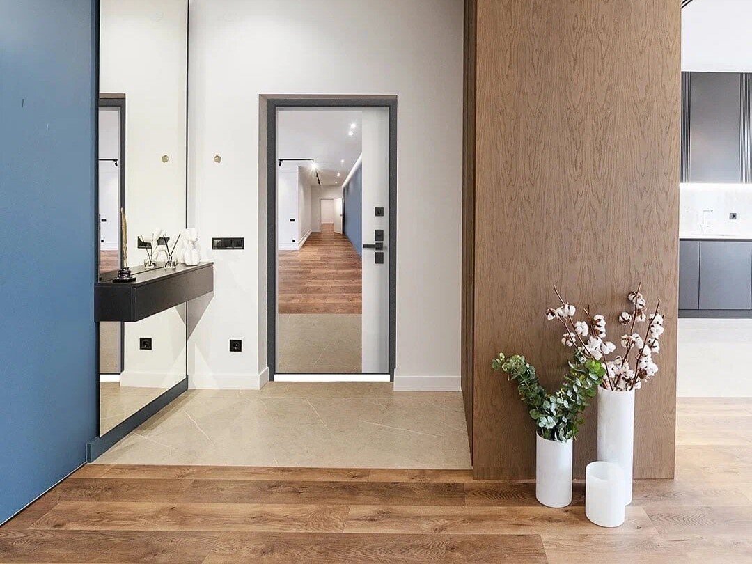 Интерьер со смешанным полом и входной дверью с зеркалом