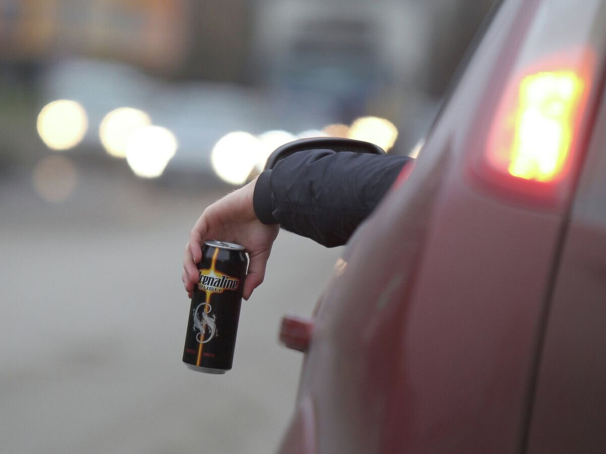    Житель Великого Новгорода пьет энергетический напиток за рулем автомобиля© РИА Новости / Константин Чалабов
