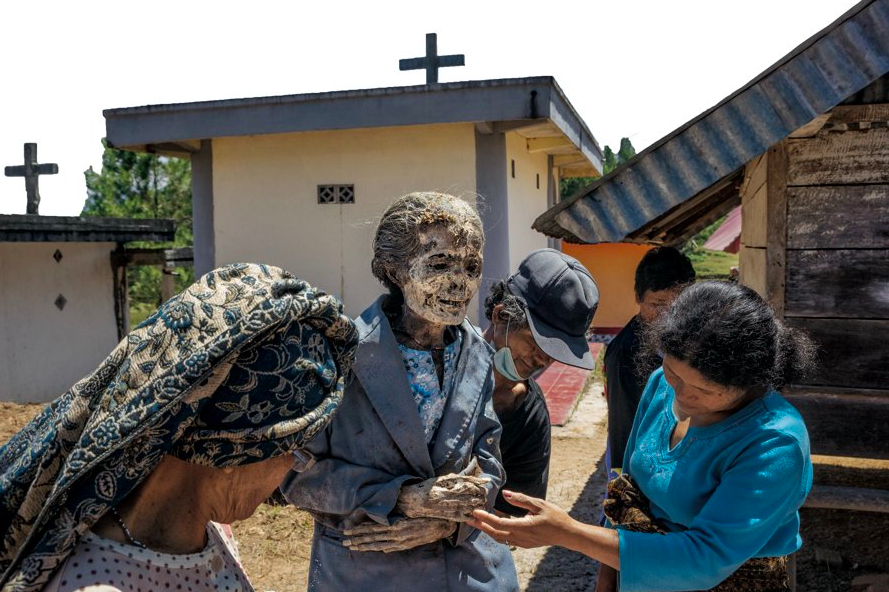 Семья и друзья осматривают тело Деборы Маупа, умершей в 2009 году в возрасте 73 лет. Мумифицированное в растворе формальдегида тело хорошо сохранилось – это к удаче. Фото: Брайан Лехманн