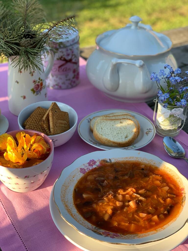 Фото: УСАДЬБУШКА. В этот раз варила борщ. Супница советская, досталась в наследство от бабушки мужа (вся посуда от моей бабушки у сестры в Латвии). От нее же привезли тарелки Дулево под первое. Хлеб лежит в тарелочке с непонятным клеймом. Цветочки на ней выцвели, но от этого она не потеряла своего очарования - настоящая старина! Справа маленький подсвечник с кружевом, который я использую как вазочку, покупала в Фикс прайс давно. 