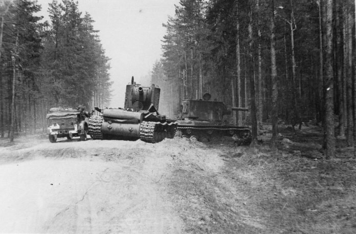 
Советские тяжелые танки КВ-2 из 18-й танковой дивизии 7-го механизированного корпуса, оставленные при отступлении Красной Армии на грунтовой дороге Сенно-Богушевское (Витебская область, Белорусская ССР). Рядом с машинами проезжает немецкий автомобиль Horch 901 (Kfz.12). Источник: https://waralbum.ru/265598/