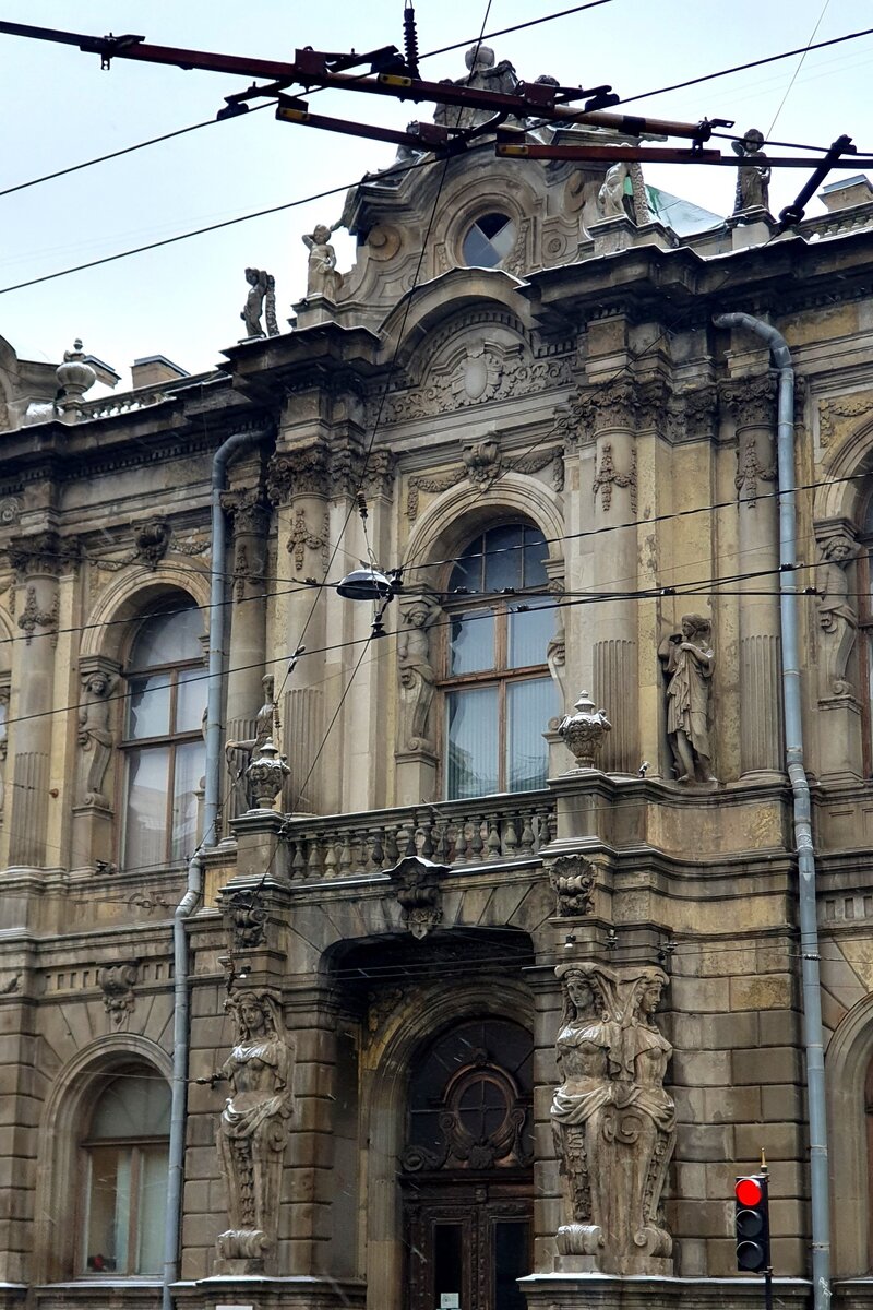 Входной портал обрамлен скульптурами кариатид, держащих балкон.