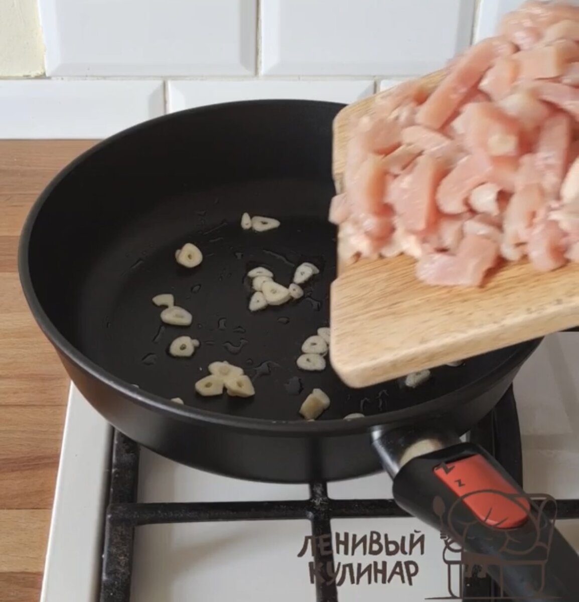 На сковороде с маслом отправляем 2-3 зубчика чеснока, нарезанного слайсами. Через минуту добавляем нарезанное небольшими кусочками куриное филе (250-300 г) . Обжариваем 12 минут. Огонь средний